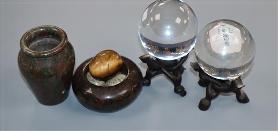 A pair of Chinese crystal spheres on hardwood stands, a hardstone vase, a hardstone nest with eggs and a small chrysoberyl egg